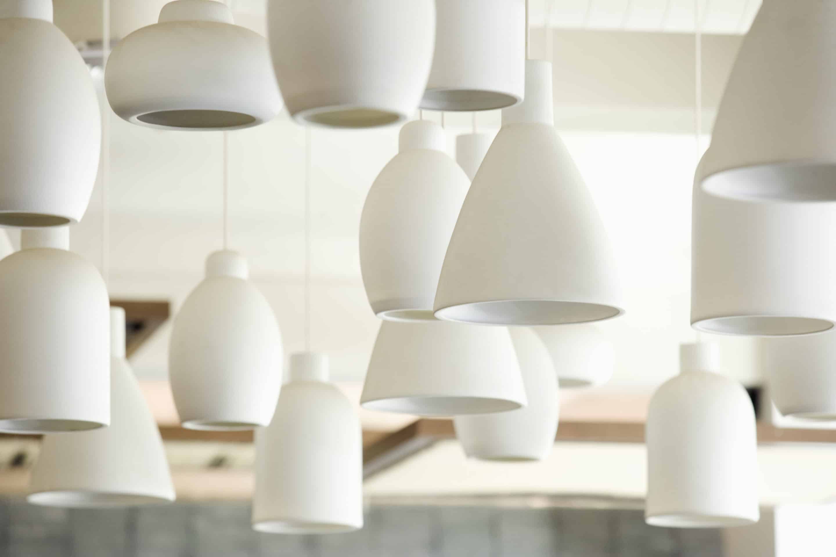 White lighting fixtures, pendant lights of varying sizes and shapes